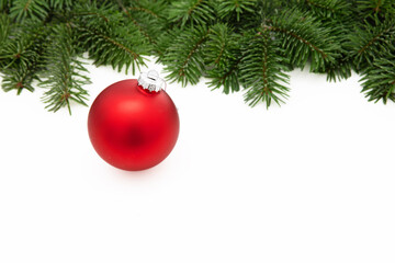Fototapeta na wymiar Christmas greeting card, red Xmas bauble on fir twig isolated on white background