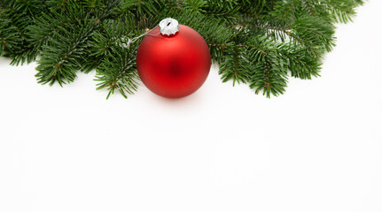 Christmas greeting card, red Xmas bauble on fir twig isolated on white background