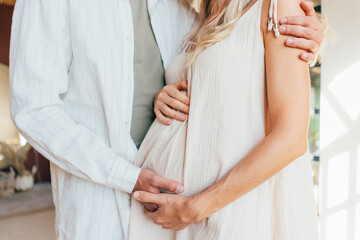 Cropped image of  pregnant woman and her  husband hugging the tummy - obrazy, fototapety, plakaty