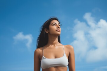 Young woman looking up at blue sky