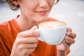 Cropped close up photo of lovely cute girl enjoying morning cappuccino in cafe outdoors