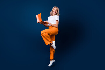 Full length photo of gorgeous cute girl wear trendy orange outfit use modern netbook macbook isolated on dark blue color background - Powered by Adobe