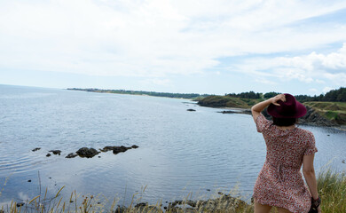 Elegant lady standing alone on the cliff edge, watching the horizon in calm contemplation, embracing freedom, discovery, and peaceful beginnings by the coastal seascape