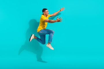 Full length profile photo of energetic crazy person jump rush hurry raise opened arms empty space isolated on teal color background