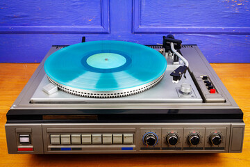 Fototapeta premium Vintage turntable vinyl record player with turquoise vinyl