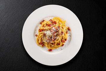 Plate of spaghetti carbonara with black pepper and pecorino cheese