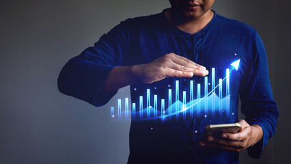 Businessman showing business growth graph from mobile phone display.