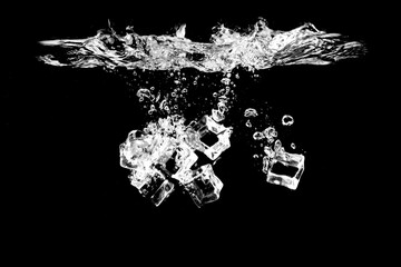Ice cubes falling on the water on a black background are refreshing.
