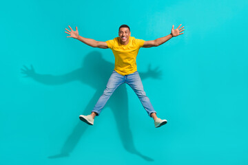 Fototapeta na wymiar Full body photo of carefree cheerful young person jumping falling make star figure isolated on teal color background