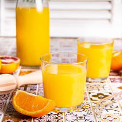 Fresh orange juice on table with slices fruits.