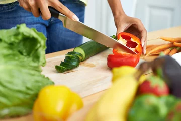 Fotobehang Woman, hands and cutting vegetables in kitchen on wooden board for healthy diet or vegetarian meal at home. Closeup of female person slicing natural organic red pepper for salad preparation at house © M Moller/peopleimages.com