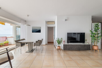 TV screen and empty dining table in comfortable apartment