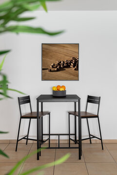 Black table with chairs and fruit bowl in dining area