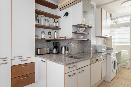 Kitchen with cabinets, sink and washing machine in flat