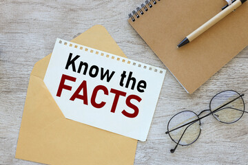 KNOW THE FACTS. text on a page in an envelope on a work desk