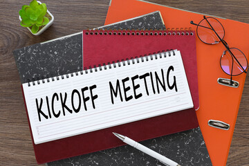 Kickoff Meeting. diary with text on orange folder - obrazy, fototapety, plakaty