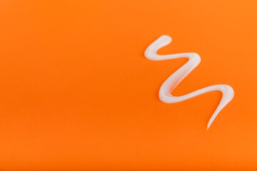 Fototapeta premium Sunscreen on an orange background. SPF cream. Sun protection. UV protection. Summer. The concept of rest and vacation. Summer mood. Design. MOCKUP. Shopping concept.