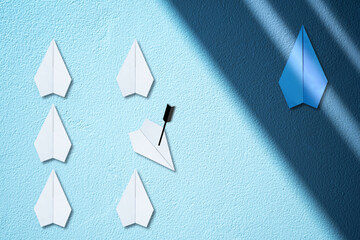 Hidden blue paper plane flying under the the shade versus white paper plane flying in the light....
