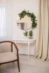 Christmas interior with upholstered furniture. Christmas tree with garlands and toys and balls.
