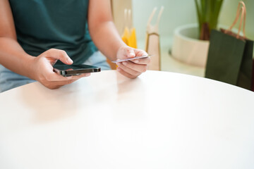 Asian woman with smart phone for online shopping.  Hand holding mobile phone with Payment on credit card online shopping electronic wallet Payment Shopping by phone connected card concept