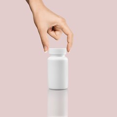 Young hand holding white blank bottle tube