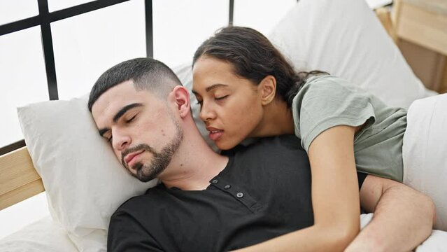 Beautiful couple lying on bed sleeping kissing at bedroom