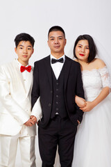 Group photo of a family of three wearing formal wedding attire