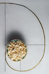 Top view bowl full of popcorn on white background with Fibonacci spiral