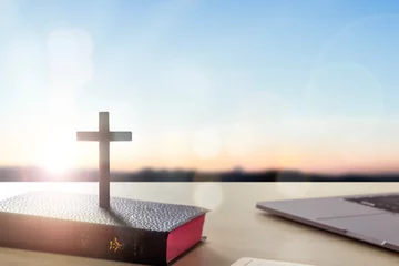 Foto op Plexiglas Silhouette wooden cross on holy bible  sunrise background © paul