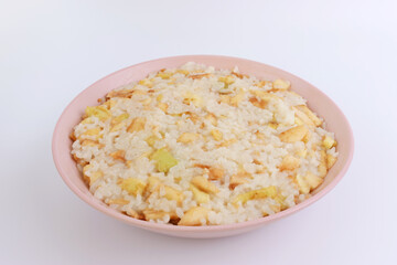 Rice porridge with apples in a pink bowl on a white background.