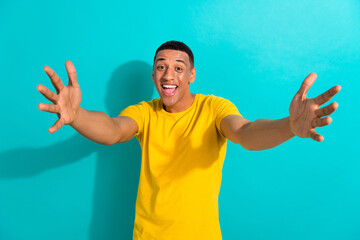 Photo of young man opening his arms excited greetings hello welcome event friendly cuddles isolated on aquamarine color background