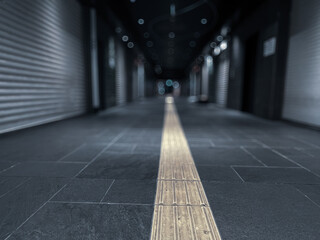 A dimly corridor w/ a yellow tactile paving, Tokyo, Japan