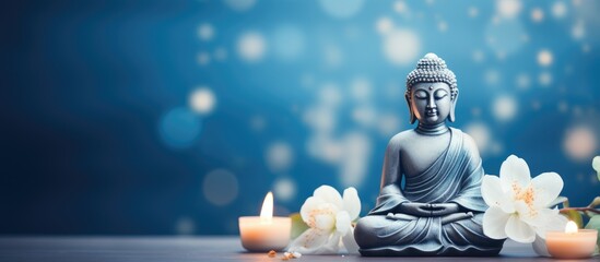 Buddhist holy day celebrating Siddhartha Gautama White flower adorned Buddha statue on blue backdrop Mental well being and meditation theme Soft focus room for text - obrazy, fototapety, plakaty