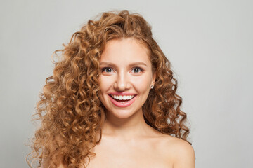 Young happy laughing woman redhead fashion model with long natural healthy brown curly hair and cute smile having fun on white background, studio portrait