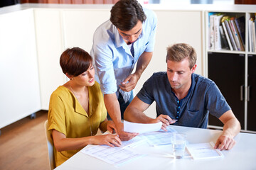 Business meeting, team and documents for brainstorming, planning or research in office with communication. Employees, men and woman with partnership, collaboration or paperwork and discussion at work