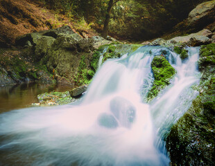 Waterfall between rocky stream in the mountains