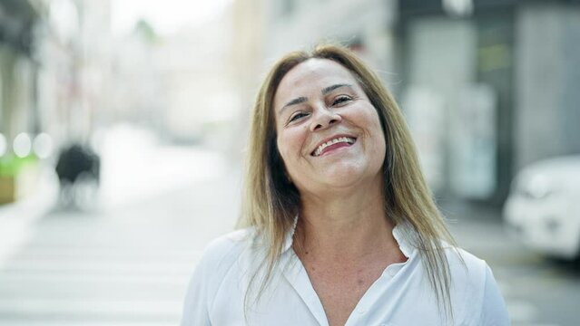 Middle age hispanic woman smiling confident standing at street