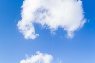 White airy beautiful clouds in a bright blue sky. Clear sunny weather. The concept of environmental safety and cleanliness.