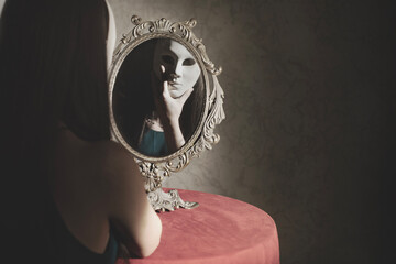 reflection of a vain woman with mask in front of the mirror, identity concept