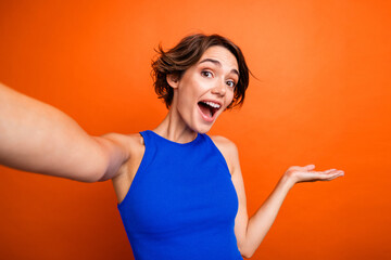 Photo of good mood cheerful lady wear blue singlet recording video vlog invite you come isolated orange color background