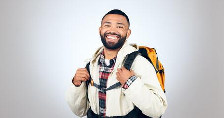 Man, portrait and hiking in studio with backpack and smile from travel and freedom with adventure. Camping, fitness and grey background and walking with trekking camper gear for vacation and holiday