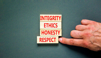 Integrity ethics honesty respect symbol. Concept word Integrity Ethics Honesty Respect on block. Beautiful grey background. Businessman hand. Business integrity ethics honesty respect concept.