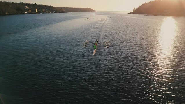 Aerial view of a crew of athletes rowing a boat at sunrise. Halifax, Canada