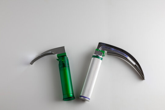 On the white table there is a child and an adult laryngoscope. Copy space.