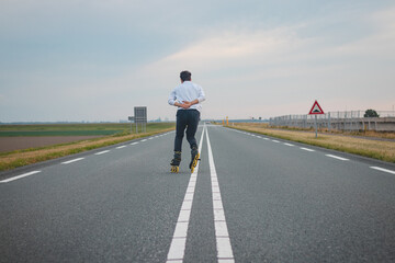 Fototapeta premium Handsome young athlete rollerblades on Dutch roads to improve endurance and fitness. A young man trains stability and enjoying the fresh air. Sport lifestyle