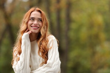 Autumn vibes. Portrait of smiling woman outdoors. Space for text