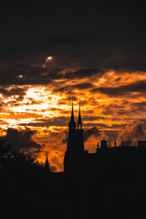 Stormy and dramatic sunset and silhouettes of the cathedral spire in Amsterdam, Netherlands