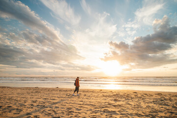 Man, a traveler watching a breathtaking sunset on the shores of the North Sea near Zandvoort,...