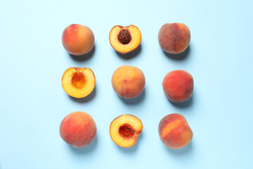 Cut and whole fresh ripe peaches on light blue background, flat lay - obrazy, fototapety, plakaty