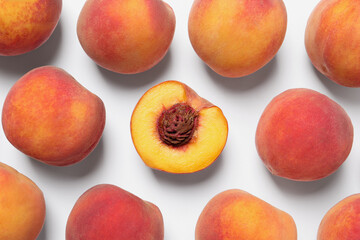 Cut and whole fresh ripe peaches on white background, flat lay
